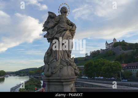 St. Kilian Statue on the Alte Mainbrücke, Würzburg with Marienberg Fortress in background Stock Photo