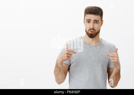 Wanna have such perfect body. Self-assured handsome man with stylish beard and hairstyle pointing at himself questioned and determined feeling confident recommending nutrition program for gym visitor Stock Photo