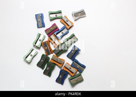 Multi coloured metal pencil sharpeners on plain background, a still life study Stock Photo