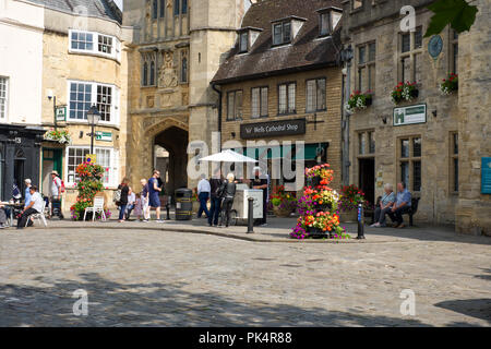 A man selling Ice Cream from a traditional styled bicycle and cart to customers on the Market Place, Wells, Somerset, UK Stock Photo