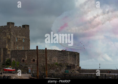Flyby past Carrickfergus Castle - The Red Arrows, the Royal Air Force aerobatics team, on display at airshow over Carrickfergus Castle, County Antrim, Stock Photo