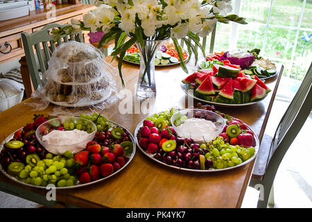 Beautiful party trays of fresh fruit on table for entertaining.  Bouquet of flowers. Stock Photo