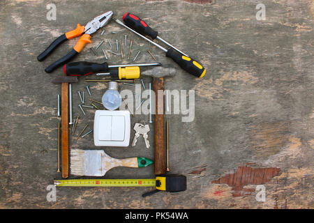 Construction tools in the form of house on wooden background. Stock Photo