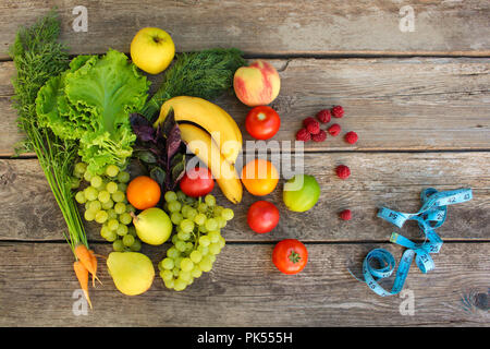 Fruits, vegetables, measure tape on wooden background. Stock Photo