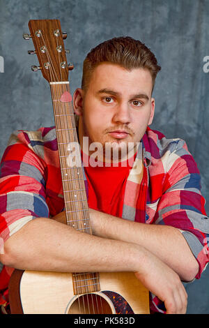 Young musician male with his acoustic guitar portrait. Stock Photo