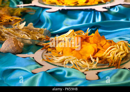 Crisps and fish snacks on the wedding table in sea style. Stock Photo