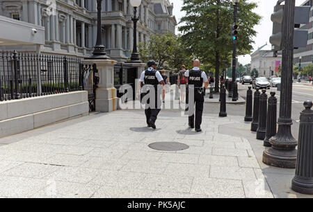 Two police patrol the sidewalk outside the Eisenhower Executive Office Building in Washington DC. Stock Photo