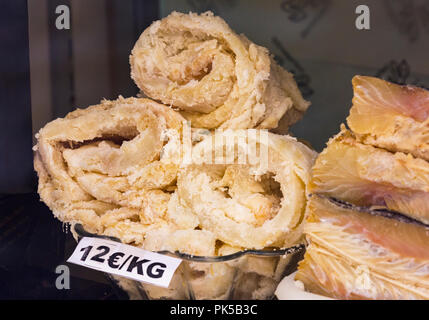 Rolls of dried codfish in Spanish shop window. The salted cod is known as bacalao in Spanish. Stock Photo