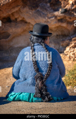 Old bolivian woman in traditional outfit with a hat and long braids Stock Photo