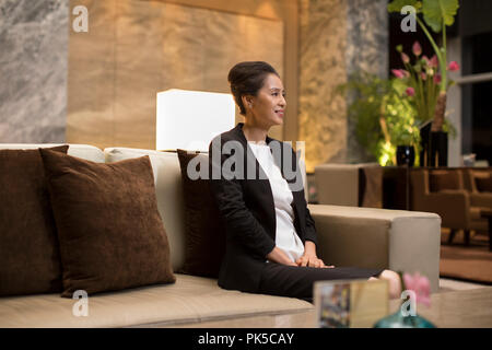 Elegant businesswoman sitting on sofa Stock Photo