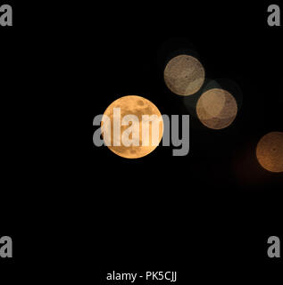 Abstract minimalist composition with interesting colored city flares and full moon obtained at night Stock Photo
