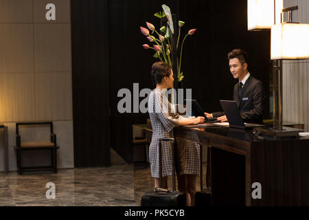 Elegant woman checking into hotel Stock Photo