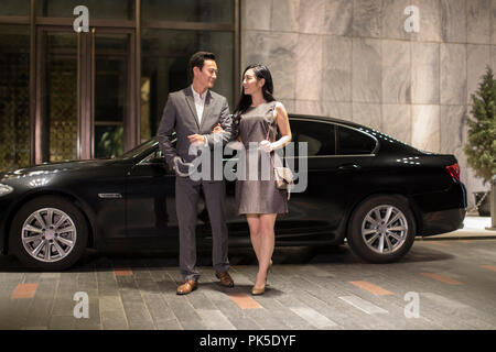 Cheerful young couple arriving at hotel by car Stock Photo