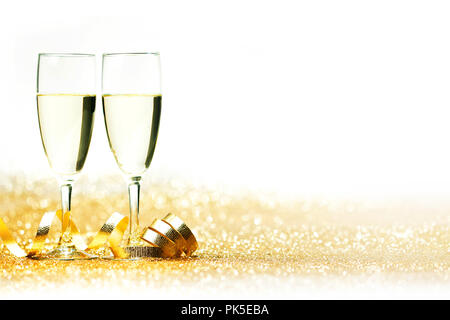 Glasses of champagne and curly decorative ribbon on golden glitters Stock Photo