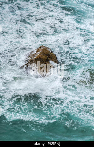 A rock in a choppy swirling sea Stock Photo - Alamy