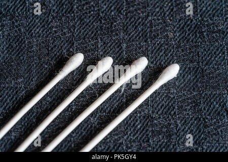 Close up of four environmentally friendly paper stemmed cotton buds against black background Stock Photo