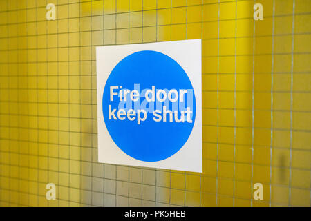Blue 'Fire door keep shut' sign inside a residential block of flats, England, UK Stock Photo
