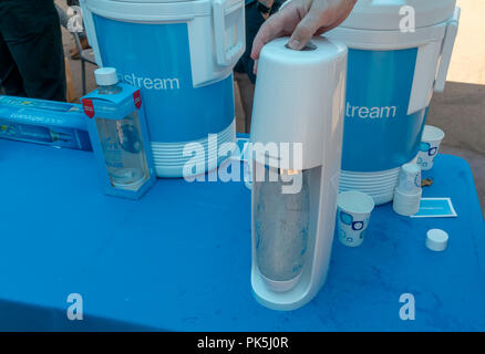 A Soda Stream worker demonstrates the carbonation method at the 'Drowning Liberty' installation unveiling at a SodaStream branding event in Flatiron Plaza in New York on Monday, September 3, 2018. The installation in partnership with the Oceanic Society consists of a 20 foot tall Lady Liberty trapped inside a cage filled with single-use containers. The event promotes the use of reusable containers, something that SodaStream does.  (Â© Richard B. Levine) Stock Photo