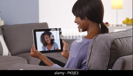 Cute black girlfriends talking talking together via internet Stock Photo
