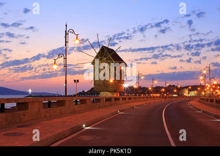 The wooden windmill on the isthmus leading to the ancient city walls and Northern harbor with Christian cross in Nesebar, Bulgaria Stock Photo