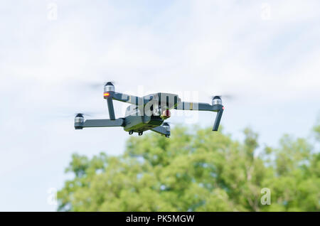 The drone hovering in a bright blue sky. Stock Photo