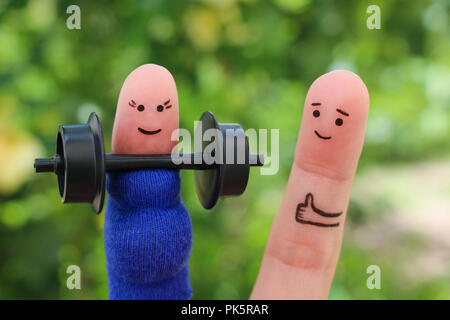 Fingers art of happy couple. Concept of pregnant woman doing sports and man supports her. Stock Photo