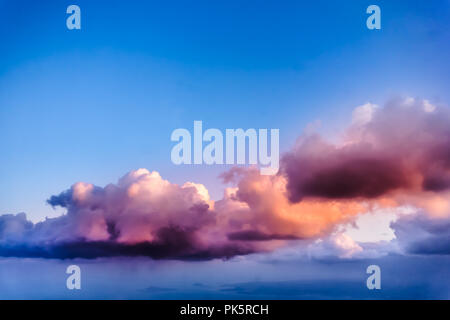 Beautiful view from airplane window, purple pink clouds with blue sky in the horizon. Stock Photo