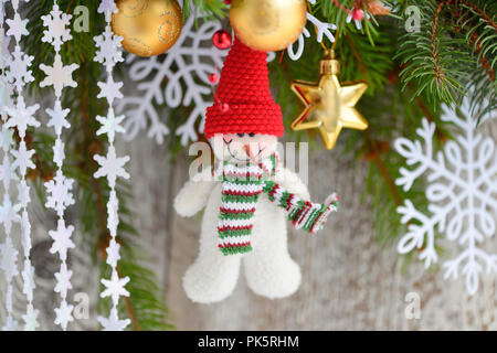 Snowman with Christmas ornaments on the branches of spruce Stock Photo