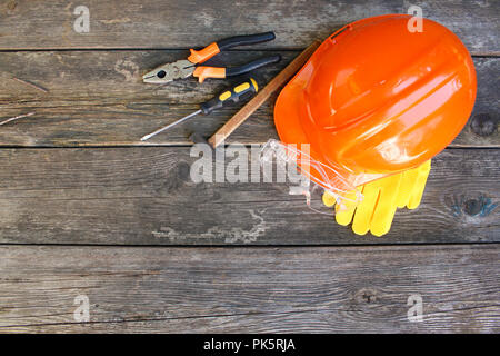 Construction tools and means of protection on an old wooden background. Top view, flat lay.