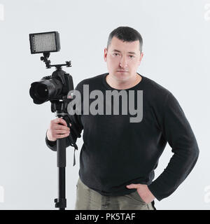 professional photographer standing near the tripod.isolated on white Stock Photo