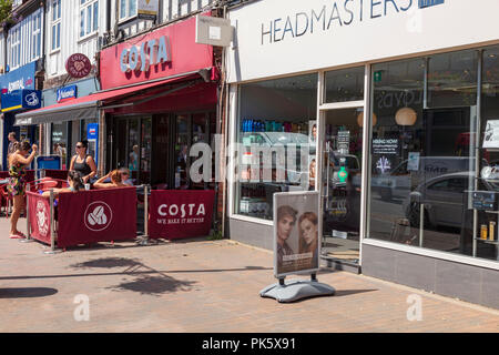 A group of women chat outside a Costa Coffee shop on Orpington High Street in the summer sun. Next door is a hairdressers, London Borough of Bromley, UK Stock Photo