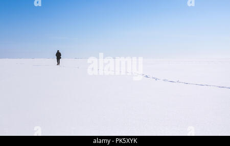 Lonely teenage girl walks along the endless snowfield, Russian winter Stock Photo