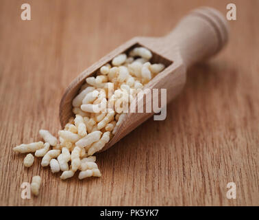 Fresh puffed rice in a wooden scoop on natural surface Stock Photo