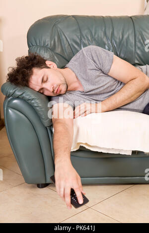 Tired young man sleeping on a sofa Stock Photo