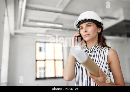 architect with blueprint calling on cell at office Stock Photo