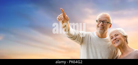 happy senior couple holding hands over evening sky Stock Photo
