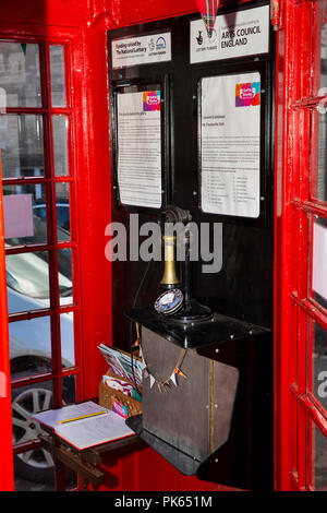 UK, Yorkshire, Settle, Duke St, Gallery with audio on old candlestick telephone, in old red K6 phone box Stock Photo