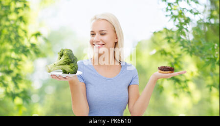 smiling woman with broccoli and donut