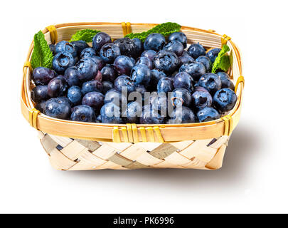 Fresh and raw blueberries in a small wicker basket. Isolated and on white background. Stock Photo