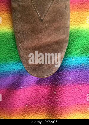 Brown shoe on rainbow fabric background. Stock Photo