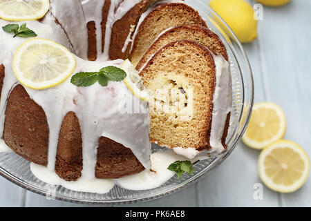 Above shot of lemon cream cheese bundt cake with cream cheese filling in the center cut into slices. Fresh lemons in background. Extreme shallow depth Stock Photo