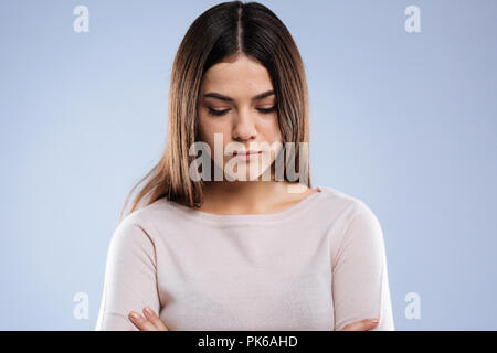 Nice young woman looking down while being sad Stock Photo