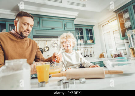 Curly preschool boy feeling excited watching father cooking Stock Photo