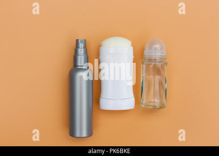 Different deodorants on beige background. Top view. Stock Photo