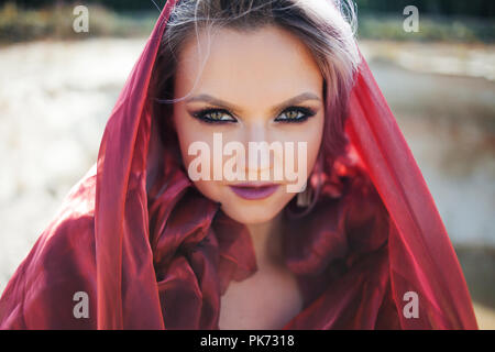Portrait in Oriental style. Young attractive woman with green eyes, a red scarf on her head. Close up Stock Photo
