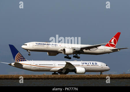 Boeing 777-3F2(ER) (TC-JJI) operated by Turkish Airlines landing past Boeing 787-9 Dreamliner (N27957) operated by United Airlines at San Francisco International Airport (KSFO), San Francisco, California, United States of America Stock Photo