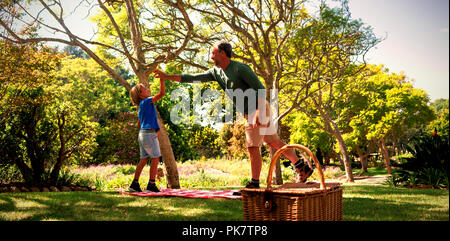 Father and son giving a high five while having picnic Stock Photo