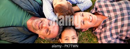 Happy family lying on the grass Stock Photo
