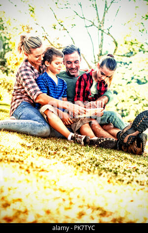 Family using digital tablet in the park Stock Photo