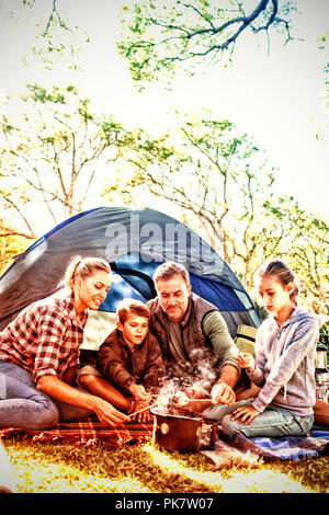 Family roasting marshmallows outside the tent Stock Photo